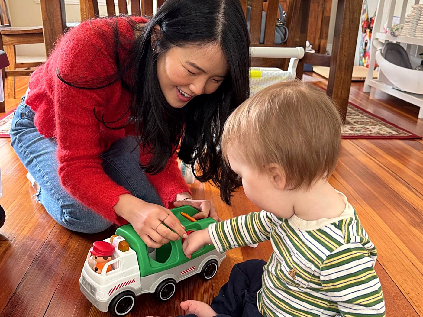 Dr. Jenny Li playing with a toy truck alongside a young child during an in-home session